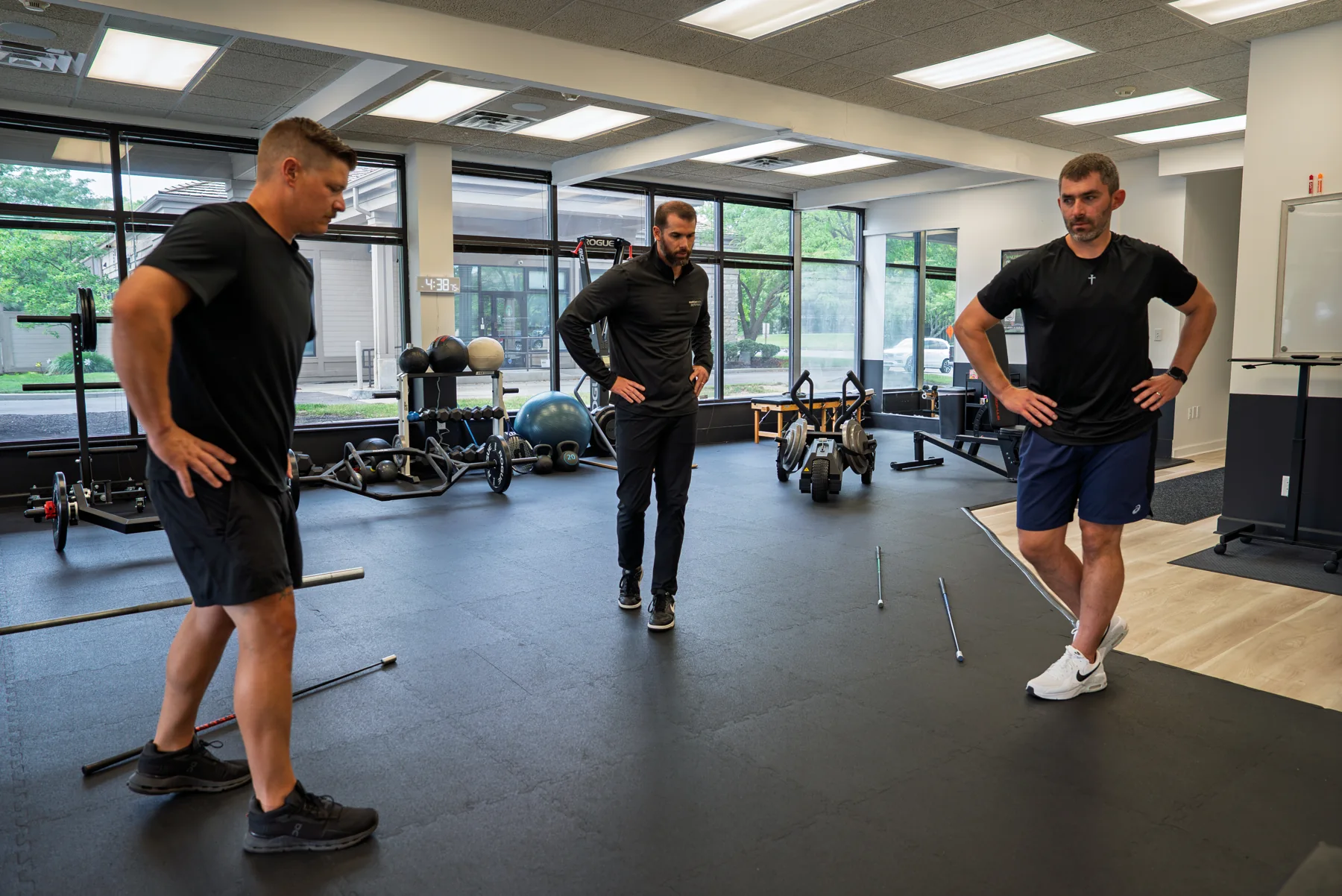 Three men during a TPI movement screen in the training studio