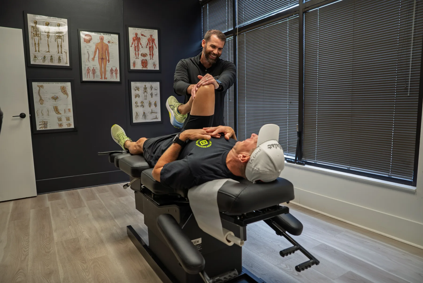 Client training a banded squat while Dr. Mathias coaches form